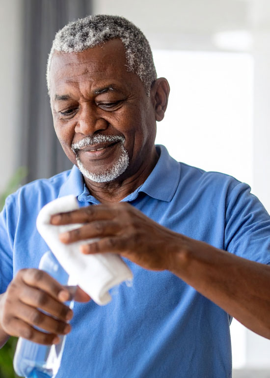 Adapter-opt Homme nettoyant avec un chiffon dans une maison.