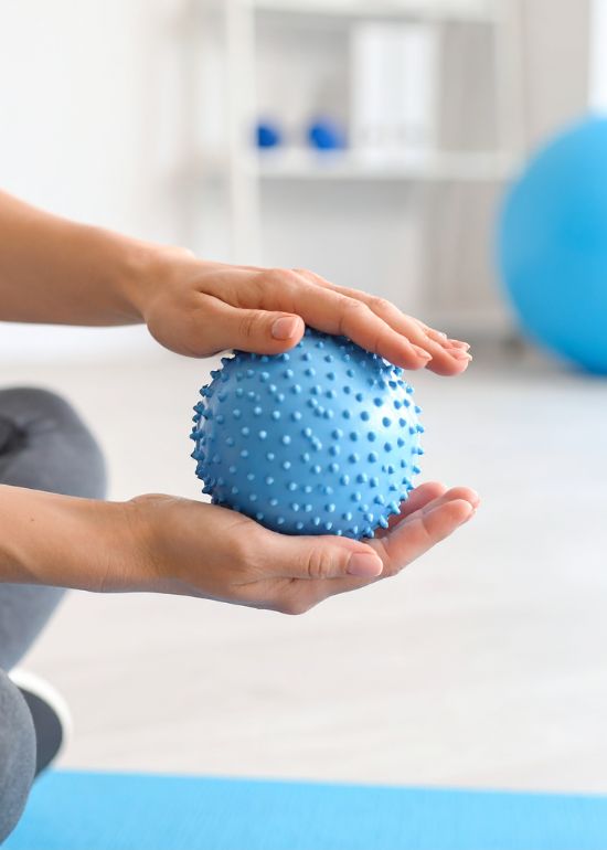Kinesitherapie Personne tenant une balle bleue en plastique