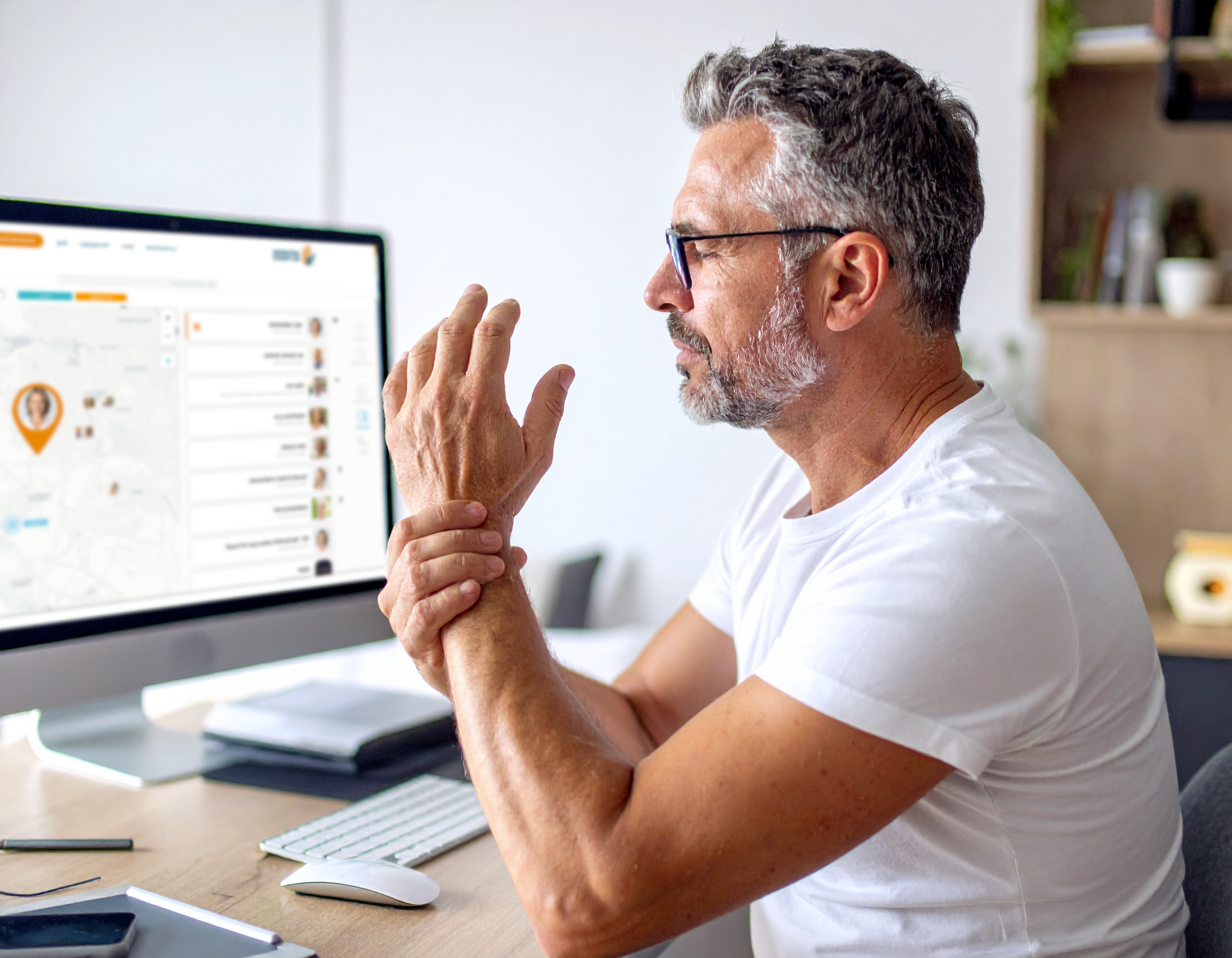Premiers_Signes Homme se massant le poignet devant l'ordinateur