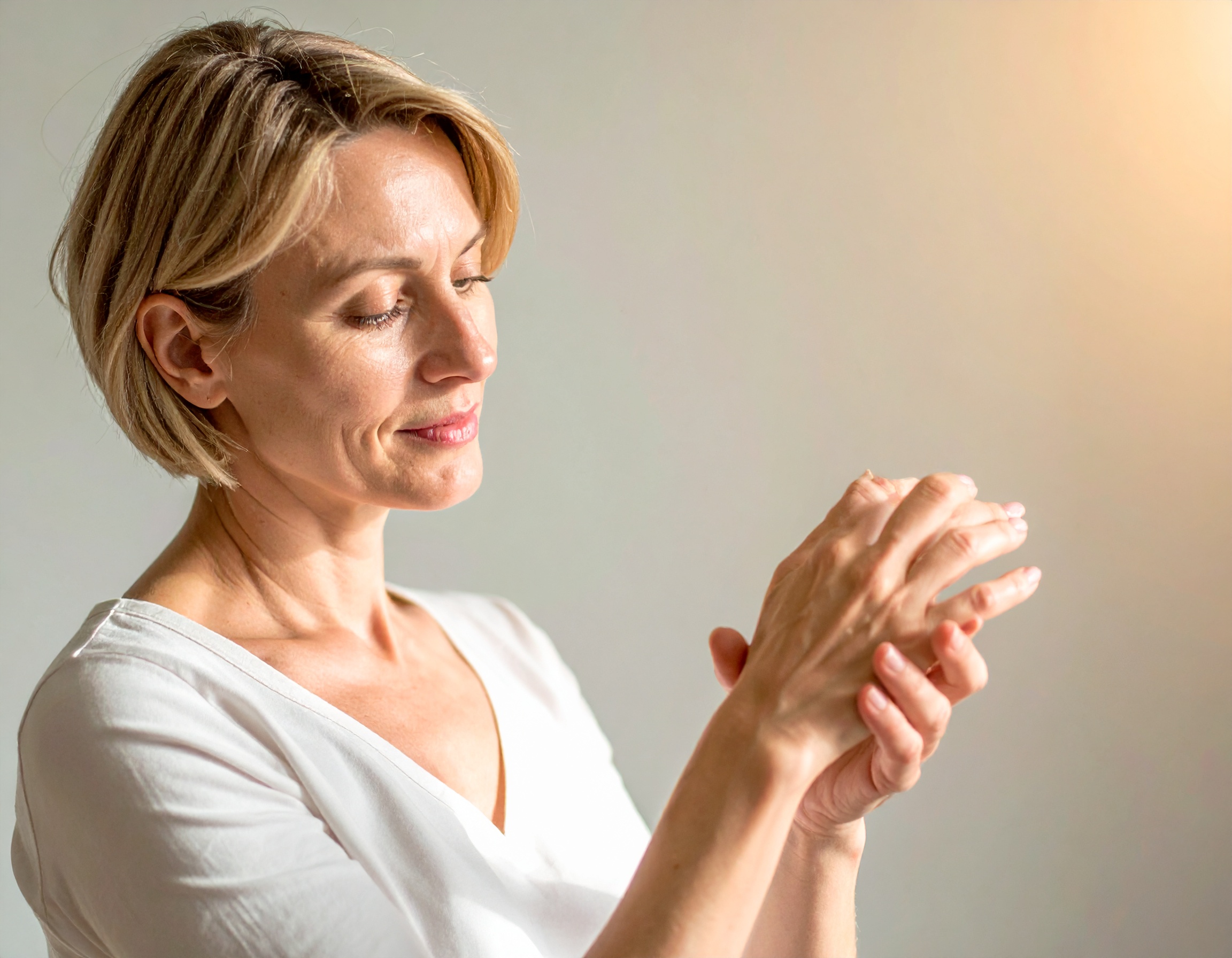 Prévenir Femme souriante massant ses mains.