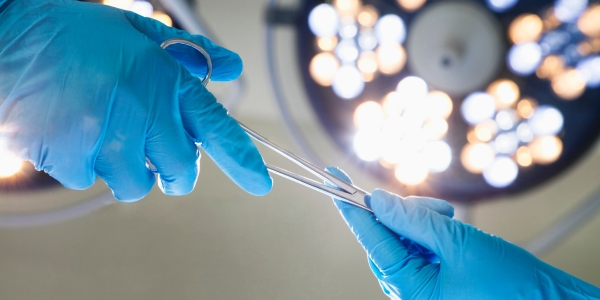 Mains avec gants en latex tenant des instruments chirurgicaux