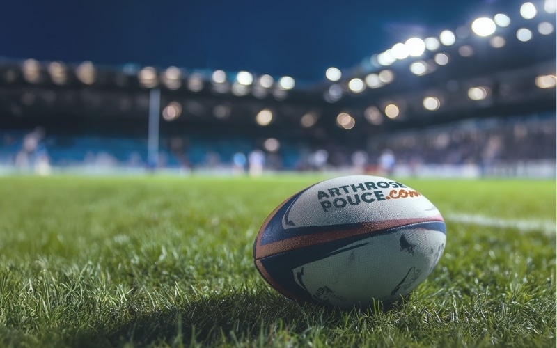 Un ballon de rugby sur le terrain au crépuscule.