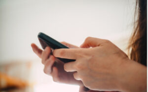 Main utilisant un smartphone pour envoyer un message.