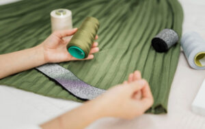 Femme cousant avec des fils colorés sur tissu