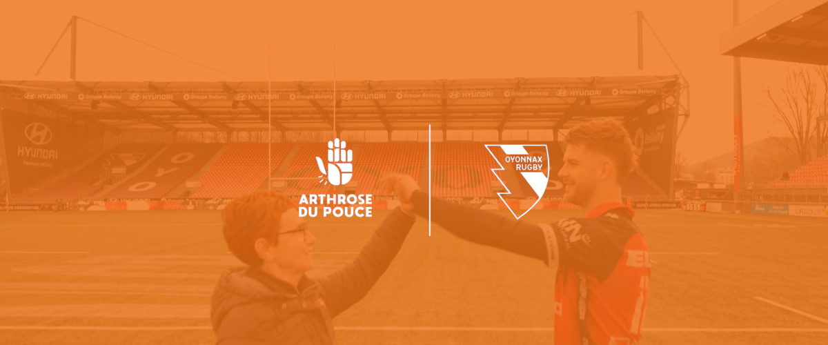 Deux personnes se saluent sur un terrain de rugby.