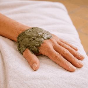 Main avec masque de beauté verte.